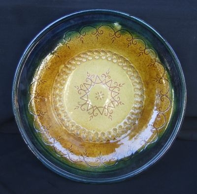 PLATE, yellow to honey and d.green wide rim glazed clay with d.brown Sun pattern in the middle, diam. 12 ½’’, Latgalian tradition, made by Juris Krompāns PLATE, yellow to honey and d.green wide rim glazed clay with d.brown Sun pattern in the middle, diam. 12 ½’’, Latgalian tradition, made by Juris Krompāns